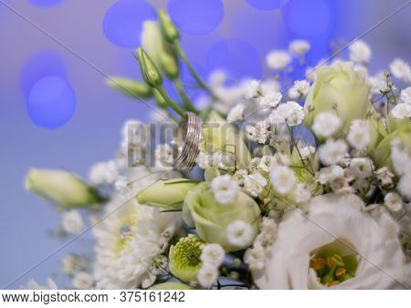 Close-up Of Two Wedding Rings On A Wedding Bouquet.