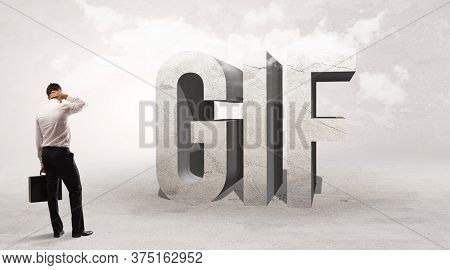 Rear view of a businessman standing in front of GIF abbreviation, attention making concept