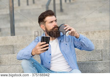 Drink It On The Go. Brutal Hipster Drink Coffee Sitting On Stairs. Bearded Man Enjoy Hot Drink Outdo