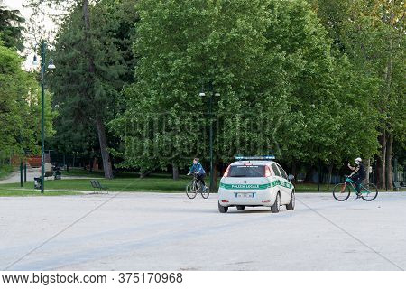 Milan, Italy - May 4, 2020: People Exercising Bicycling Outdoor Wearing Face Mask. Police Patrol In 
