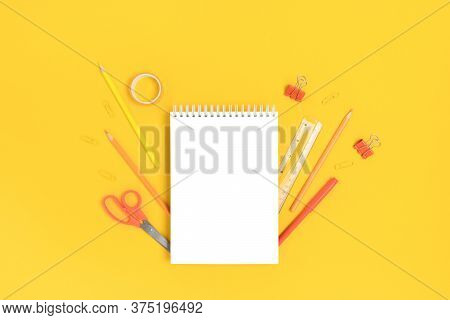 Notepad Mockup With Stationery On A Bright Yellow Background. Monochrome Ack To School Concept.