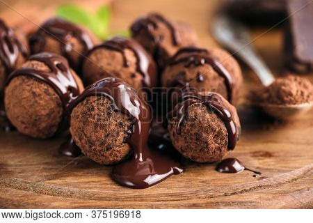 Homemade Chocolate Candy Truffles Glazed With Chocolate Ganache On A Wooden Board, Closeup View
