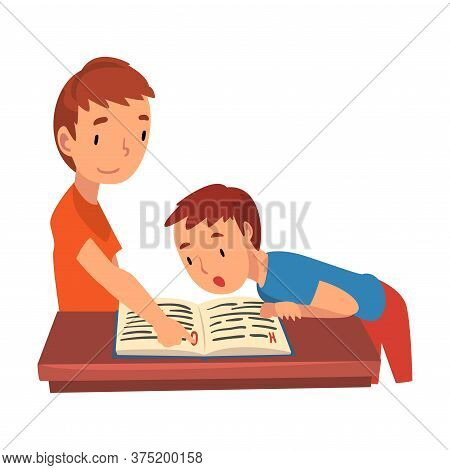 Cute Two Schoolboys Standing At Desk And Reading Book, Boy Helping His Younger Brother With Homework