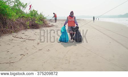 Morjim, India December 14, 2019: Cleaners Establish Order On Seacoast From Garbage. Workers Make Cle