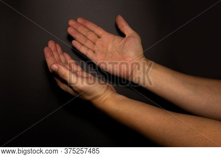 The Man Whose Hand Is Praying On The Dark Background,selective Focus.