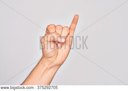 Hand of caucasian young man showing fingers over isolated white background showing little finger as pinky promise commitment, number one