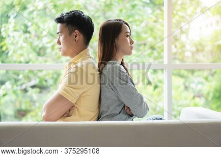 Unhappy Couple Sitting Behind Each Other On The Couch And Avoid Talking Or Looking At Each Other, Ca