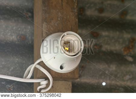 Lamp Holder Is Mounted On Wood And Old Zinc Blurred Background.