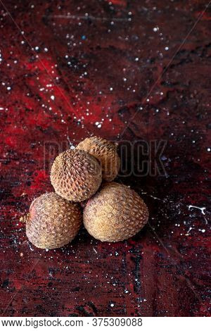 Ripe Lychee Or Lichi Isolated On Reddish Background In Vertical Orientation