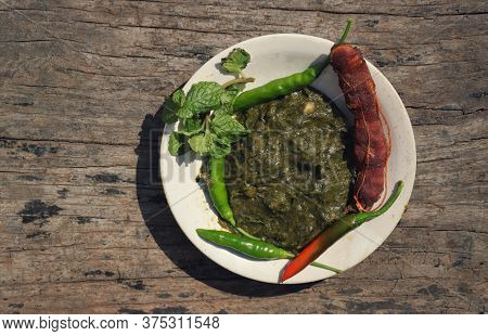 Top View Of Pudina Chutney Or Field Mint Leaves Paste In A Plate On Wooden Background With Copy Spac