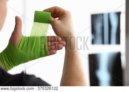 Man Rewinds His Hand With Bandage On An X-ray. Bandage For Inflammatory Processes And Seizures. Band