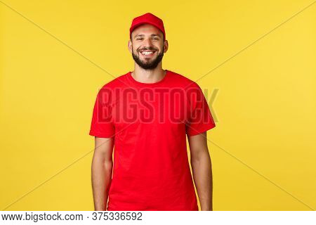 Express Mail Delivery, Package Transfer And Logistics Concept. Cheerful Young Bearded Courier In Red