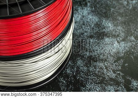 Two Coils Of Filament For 3d Printing. Bright Thermoplastic Of Red And Silver Colors. Reels Horizont