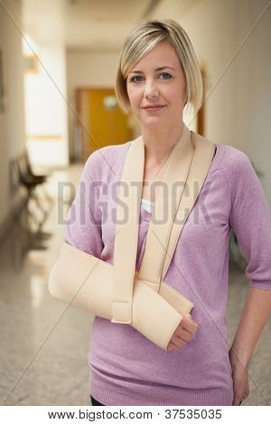 病院の廊下にスリングで腕を持つ患者