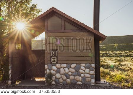 Rustic Pit Toliet Bathroom In Grand Teton National Park Wyoming, During Sunrise, With Beautiful Sunf