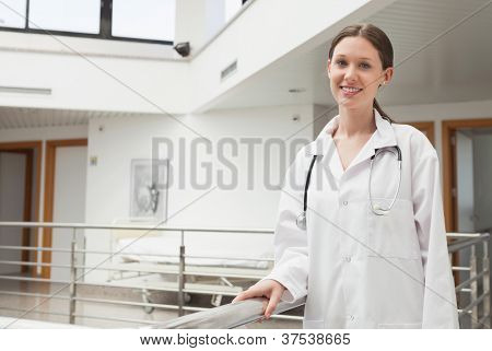 Kadın doktor, hastane merdiven boşluğu korkuluk üzerine eğilerek