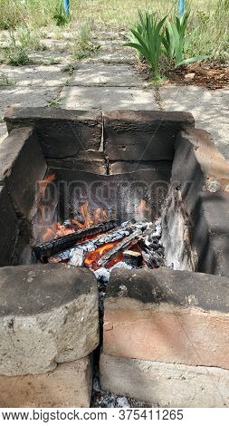 Rustic Mangal Made From Cracked Burnt Terracotta Bricks With Smoky Surface. Flaming Fire Inside Old 