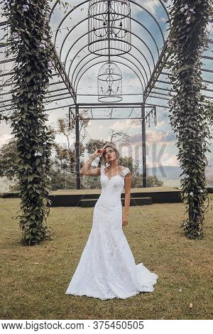 Beautiful Bride In Her Wedding Dress Posing For Photos.