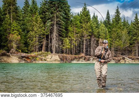 Kitimat, British Columbia, Canada - July 27th, 2015: A Sport Fly Fisherman Hooked Into A Salmon On T
