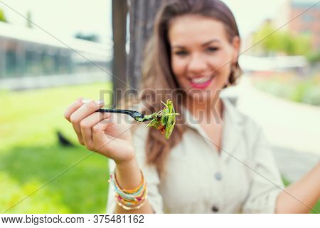Young Cheeerful Latina Woman Holding Salad, Depth Of Field