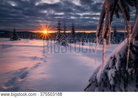 Beautiful Sunset During Winter On Top Of Mountains With Footprints Going Towards The Setting Sun Nea