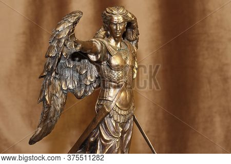 Statuette Of The Archangel Michael On A Velour Background.