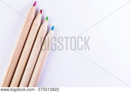 Four Colored Wooden Pencils On White Background