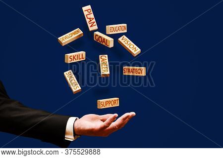 Career Concept. A Man Throws Up Wooden Blocks With The Words Strategy, Success, Vision, Development,