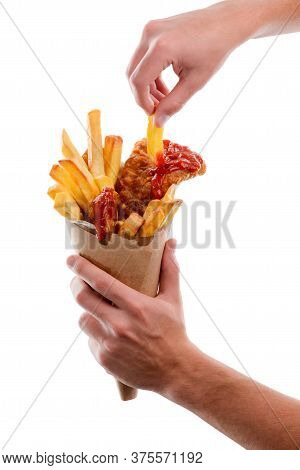 Male Hand Is Taking A French Frie From Paper Cone Wrapper