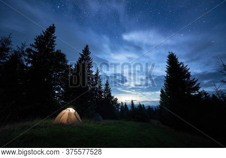 Magnificent View Of Night Blue Sky Over Meadow With Illuminated Camp Tent. Fantastic Scenery Of Tour