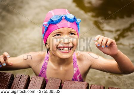 Young Small Tired 9 Years Old Girl Swimmer On Finish Line After Open Water Competition For Children.