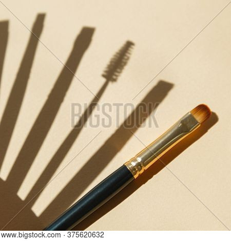 Set Of Gold And Black Brow Brushes Concept. Makeup Artists Brushes On An Isolated Background.