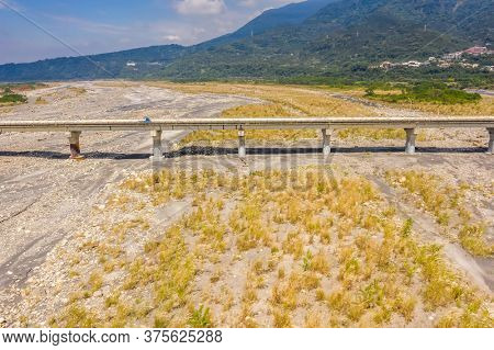 bridge over river with golden miscanthus under sky