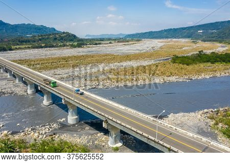 bridge over river with golden miscanthus under sky