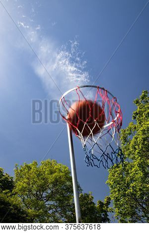 Moving Netball Hits Through The Scoring Net With Cloud Trail Giving The Impression Of Force And Spee