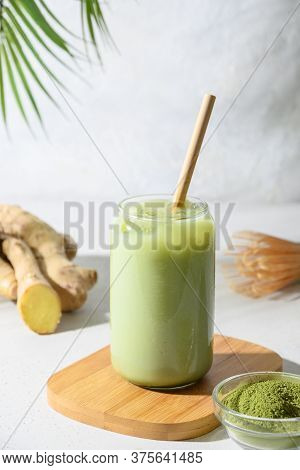 Iced Green Matcha Latte Tea With Ginger And Ice Cube. Close Up.