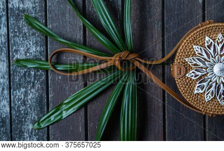 Fashionable Handmade Natural Organic Summer Rattan Bag Decoarated With Shells On Rustic Wooden Backg