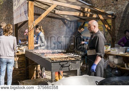 Ukraine, Lutsk - June 5, 2019: Man Is Cooking A Meat On A Grill On A Food Fest.