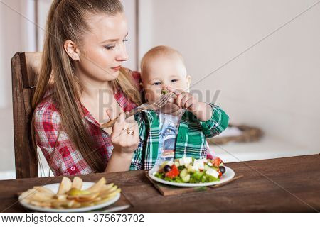 Mother Feeding Child. First Solid Food For Young Kid.