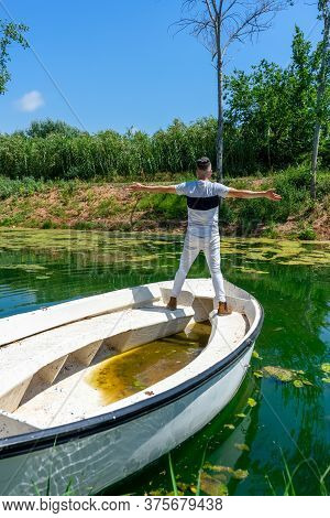Young Man In White Pants And Modern Styling Posing In The Freshwater Pond Of Clot De La Mare De Deu 