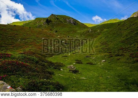 Path Climbs Between The Alpine And Granite Rocks Of Lagorai With Cloudy Skies Near Lake Levico In Tr