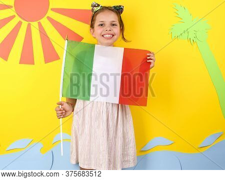 Little Girl On A Bright Background With Italian Flag. The Concept Of Summer, Beach Holidays And Vaca