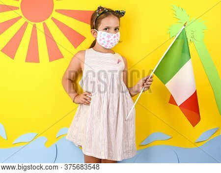 Little Girl In A Protective Mask During The Coronvirus Pandemic With The Italian Flag. The Concept O