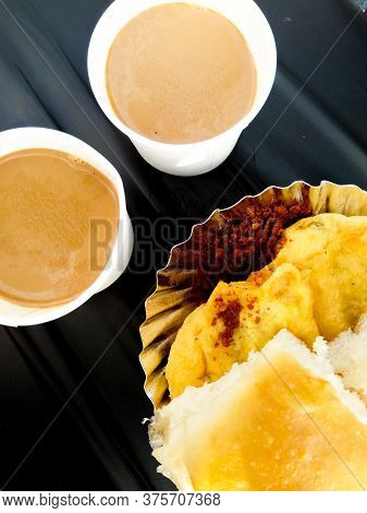 Photo Of Vada Pav, The Indian Desi Burger, And 2 Glass Tea On A Bike Seat.