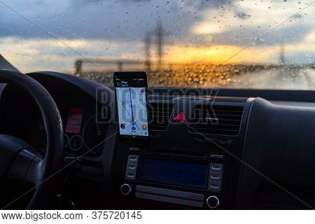 Using Waze Maps Application On Smartphone On Car Dashboard, Driver Using Maps App For Showing The Ri