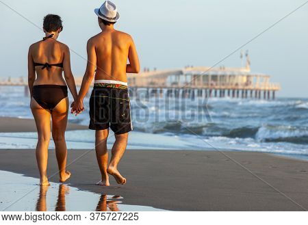 Lido Di Camaiore, Italy - September 5, 2011: Romantic Walk Of A Couple In Love On The Beach In  Lido