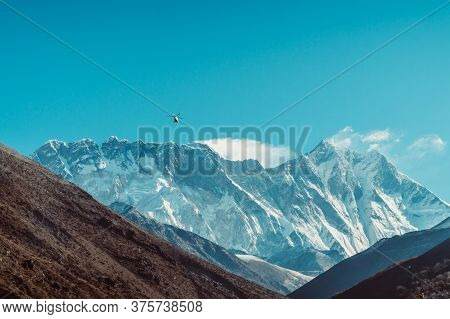 Helicopter Flies Over The Khumbu Valley, Himalaya, Nepal. Himalaya Landscape And Mountain Views.