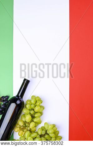 A Bottle Of Wine, Grapes, And The Flag Of Italy Close-up. Country Symbol Backdrop. The Concept Of Ha