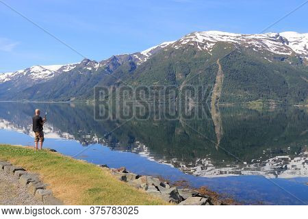 Hardanger Fiord, Norway - July 17, 2015: Man Enjoys Angling At Sorfjord Part Of Hardanger Fiord, Nor