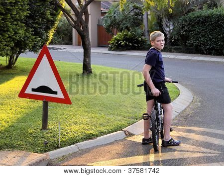 Menino parou a bicicleta na lombada